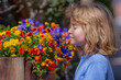 © Volodymyr - The kid smelling spring flowers in blossoms park. Kids face in blossom branches. Pretty child boy 10 year old with flowers over spring blooming nature background close up. Spring season. Childhood.