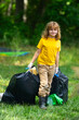 © Volodymyr - Environment plastic pollution. Volunteer kid collecting trash in the forest and holding a garbage bag. Environmental protection. Environmental Activist. Environmental conservation and waste pollution.
