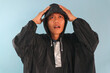 © Lailar Studio - Asian man wearing a raincoat while thinking about something