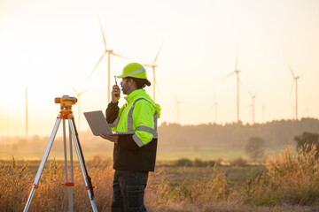 Wall Mural - engineer with laptop survey work in wind turbine farms rotation to generate electricity energy. main