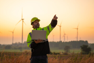 Wall Mural - engineer with laptop survey work in wind turbine farms rotation to generate electricity energy. main