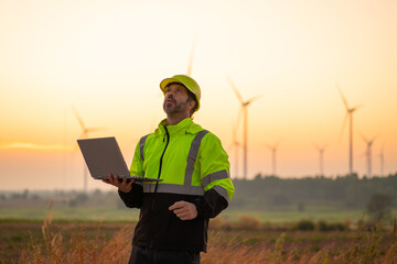 Wall Mural - engineer with laptop survey work in wind turbine farms rotation to generate electricity energy. main