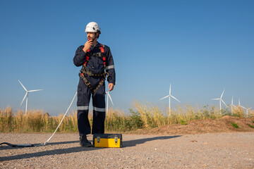 Wall Mural - engineer wearing uniform inspection and survey work in wind turbine farms rotation to generate elect