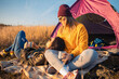 © Zoran Zeremski - Two women camping at top of the hill sitting in front of the tent.