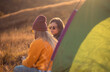 © Zoran Zeremski - Two women camping at top of the hill sitting in front of the tent.
