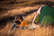 © Zoran Zeremski - Two women camping at top of the hill sitting in front of the tent.