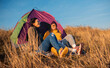 © Zoran Zeremski - Two women camping at top of the hill sitting in front of the tent.
