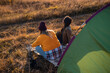 © Zoran Zeremski - Two women camping at top of the hill sitting in front of the tent.