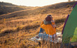 © Zoran Zeremski - Two women camping at top of the hill sitting in front of the tent.