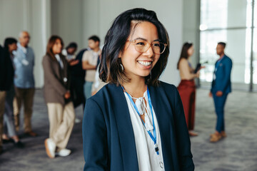 Wall Mural - smiling woman enjoying participation at a workshop with colleagues in the background sharing ideas