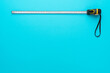 © Ruslan Grumble - Top view minimalist photo of tape measure on turquoise blue background with copy space. Flat lay image of construction measuring tape.