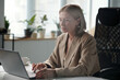 © TrueFrame Collective - Serious female owner of business company looking at laptop screen while analyzing financial situation on market