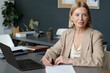 © Clique Images - Experienced female economist or director of business company sitting by workplace and signing contract