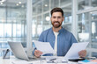 © Liubomir - Portrait of successful financier doing paperwork, man with contracts and reports smiling and looking at camera, businessman is a joyful investor.