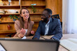 © DusanJelicic - Two smiling businesspeople engaging in a video conference on a laptop, discussing strategies and projects in their modern office, showcasing collaboration and teamwork