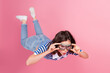 © deagreez - Young woman floating with fun expression wearing striped knitwear top on pink background