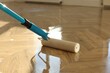 © New Africa - Polishing parquet with roller and varnish indoors, closeup