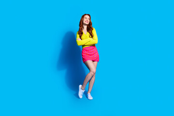 Wall Mural - Full length photo of lovely young lady crossed hands confident look empty space dressed stylish yellow garment isolated on blue color background