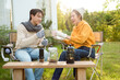 © tonefotografia - Enjoying Warm Drinks and Conversation in a Sunny Outdoor Garden During Autumn Afternoon