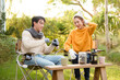 © tonefotografia - Enjoying Warm Drinks and Conversation in a Sunny Outdoor Garden During Autumn Afternoon
