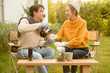 © tonefotografia - Enjoying Warm Drinks and Conversation in a Sunny Outdoor Garden During Autumn Afternoon