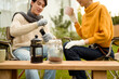 © tonefotografia - Enjoying Warm Drinks and Conversation in a Sunny Outdoor Garden During Autumn Afternoon