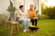 © tonefotografia - Couple Enjoys Grilling Outdoors in a Cozy Garden Setting During a Sunny Afternoon