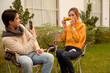 © tonefotografia - Couple Enjoys Grilling Outdoors in a Cozy Garden Setting During a Sunny Afternoon
