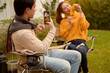 © tonefotografia - Couple Enjoys Grilling Outdoors in a Cozy Garden Setting During a Sunny Afternoon