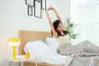 © tonefotografia - Young asian woman stretching in bed after Waking up in the Morning.