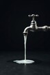 © vattana - A metallic faucet pours a continuous stream of creamy white liquid onto a dark surface