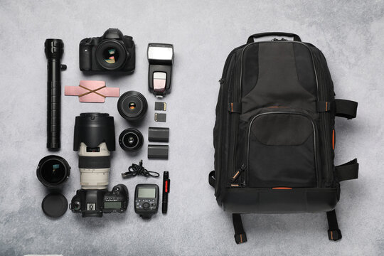 Wall Mural -  - professional photographer's equipment and backpack on light background, flat lay