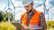 © Nova Zigres - Man technician engineer with wind turbines in the background. Eolic park and renewable energy concepts.