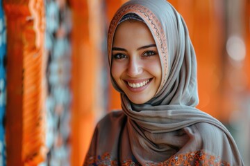 Wall Mural - portrait of beautiful young smiling muslim woman in traditional religious hijab on orange background