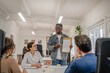 © Miljan Živković - young afro american businessman representing statistics to his work team