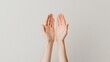 © Premium_art - Two open hands raised against a light gray background.