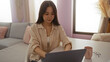 © Krakenimages.com - Young chinese woman using a laptop at home in a cozy living room