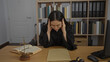 © Krakenimages.com - Stressed woman judge in office workplace indoors reading legal documents with glasses