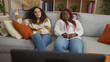 © Krakenimages.com - Women friends relaxing together indoors on a sofa in a cozy apartment living room chatting and enjoying each other's company on a comfortable afternoon.