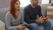 © Krakenimages.com - Man and woman enjoying video gaming together indoors on a cozy sofa, showcasing their shared interest and relationship in a home setting