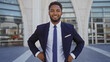 © Krakenimages.com - Handsome young african man in a suit smiling confidently standing outdoors in an urban city street environment