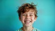 © miss irine - Teenage boy with braces smiles broadly against plain blue backdrop. Boy expressive face. Looks happy, healthy. Portrait style photo shows teeth alignment treatment. Image ideal for dental health