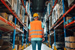 © Zamrznuti tonovi - Warehouse worker walking through storage area checking goods and supplies