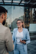 © Zamrznuti tonovi - Businesswoman holding tablet smiling while shaking hands with colleague
