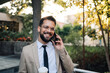 © Zamrznuti tonovi - Happy businessman talking on the phone walking in the city