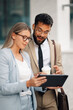 © Zamrznuti tonovi - Business people having conversation about work on tablet outside office building