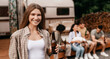 © Prostock-studio - Smiling young woman holding bottle of beer, having fun camping trip together with her multiracial friends, enjoying summer vacation, having student party outdoors, copy space