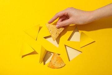 Wall Mural - Triangular potato chips on a yellow background