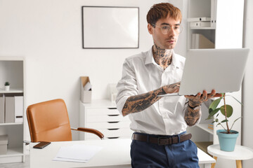 Sticker - Young tattooed businessman working with laptop in office