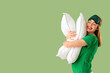© Pixel-Shot - Beautiful young woman in sleep mask with white soft pillows on green background